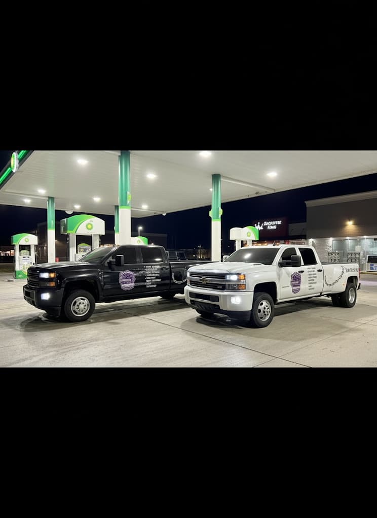 Two Prime O Towing Chevrolet Silverado tow trucks refueling at a BP gas station in Metro Detroit — 24/7 fleet on call
